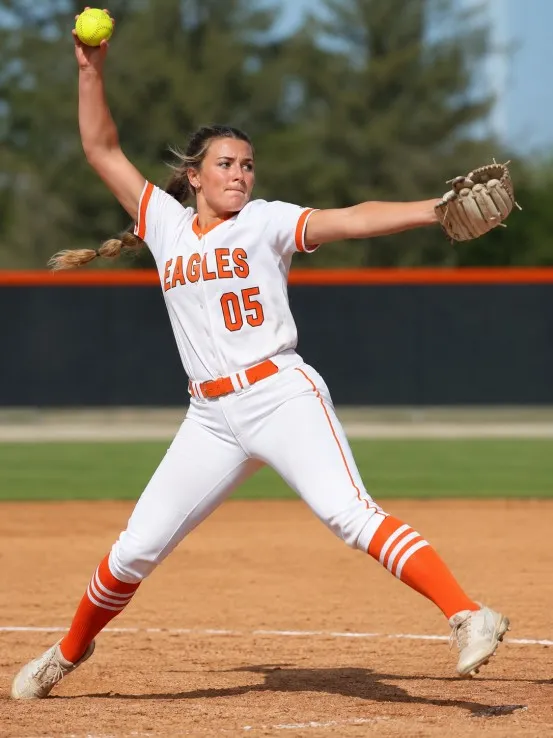Softball player wearing custom sports apparel while pitching
