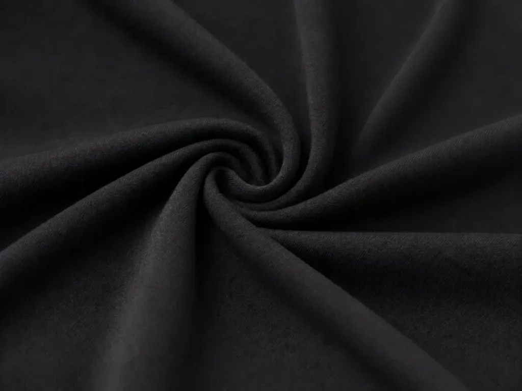 Close-up of black poly-spandex stretch knit fabric with a detail view showing the fabric stretching.
