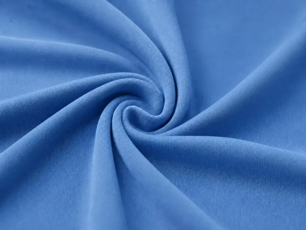 Close-up of blue polyester interlock fabric with a smooth surface and an enlarged fabric detail.