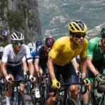 Cyclists wearing different colors cycling jerseys during a mountain road race.