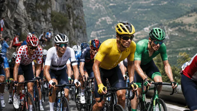Cyclists wearing different colors cycling jerseys during a mountain road race.