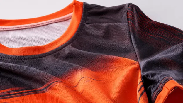 Close-up of orange and black jersey fabric showing the smooth material and stitching.